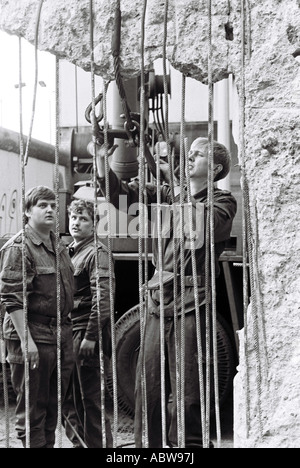 Soldiers repair a hole in the Berlin wall separating east & west Berlin. 1989 Stock Photo