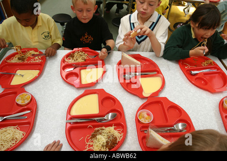 Children eating dinner at junior primary school, Betty Layward school, London, UK. 2004. Stock Photo