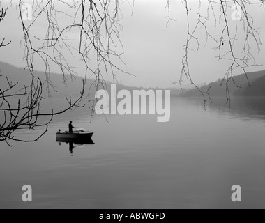 Lone man in a boat fishing on a lake Stock Photo