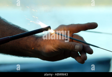 Lighting a sparkler on 4th of july Stock Photo