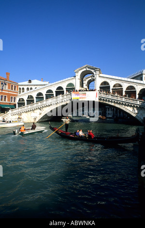 Gondola ride in canal approaching the famous Rialto Bridge in picturesque Venice Italy Stock Photo