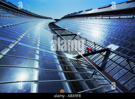 Up on the roof,  blue collar worker in hard hat on a beam over Brighton Station Stock Photo