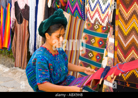 Woman using hand loom weaving artwork outside in Villa Santa Catarina in remote Lake Atitlan Guatemala Stock Photo