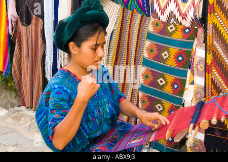 Woman using hand loom weaving artwork outside in Villa Santa Catarina in remote Lake Atitlan Guatemala Stock Photo