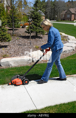 Adult female uses power electrical edging tool to enhance the ...