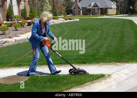 Adult female uses power electrical edging tool to enhance the ...