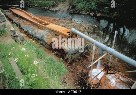 Removal of red ochre pollution from a river; pollution of the Hagg Beck, at Skinningrove, Cleveland, England, UK. Stock Photo