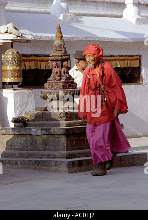 Old man in red walking around the stupa of Bouddhanath near Kathmandu Nepal South Asia Stock Photo