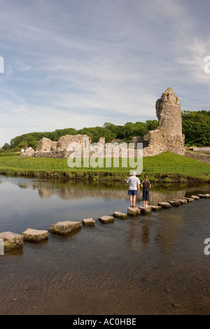 Wales Glamorgan Ogmore Castle visitors on stepping stones over Ogmore River Stock Photo
