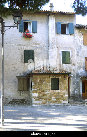 A man looks out the window of his house in the town of Grado, Italy. Stock Photo