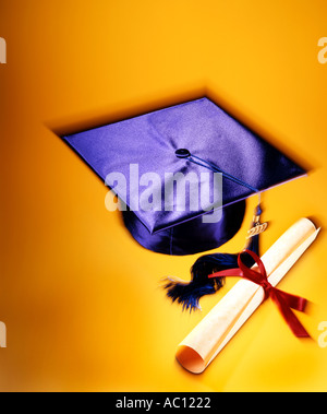 graduation cap and diploma on bright yellow background Stock Photo