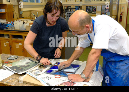 Female teacher teaching adult education evening class in stain glass making. Stock Photo