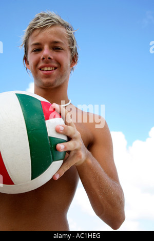 Young man holding beachvolleyball Stock Photo