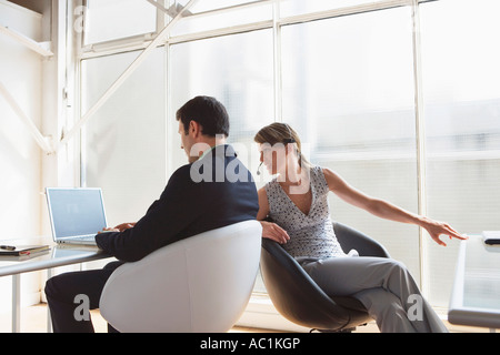Business man working on laptop, female colleague with headset Stock Photo