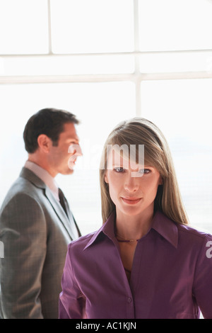 Portrait of business woman, male colleague in background Stock Photo