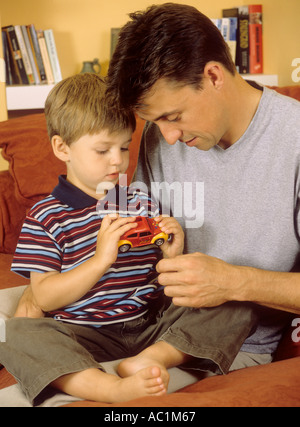 Young boy with dad looking at toy car Stock Photo