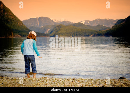 little girl standing on the shore of Alouette lake in Golden ears provincial park canada Stock Photo