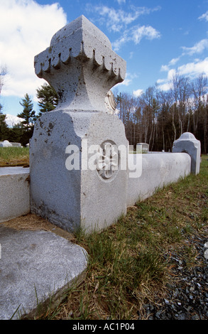 Granite wall around Old Headstones in a New England graveyard cemetery located in New Hampshire USA vertical Stock Photo
