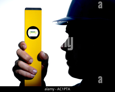 silhouette of builder in safety hard hat holding spirit level Stock Photo