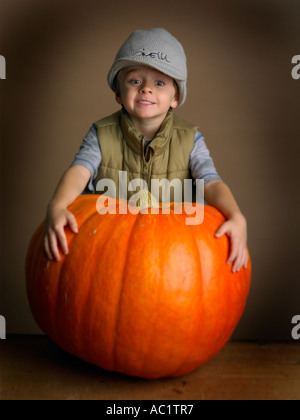 young boy in hat showing of his prize pumpkin Stock Photo