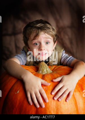 young boy  hugging of his prize pumpkin looking excited Stock Photo