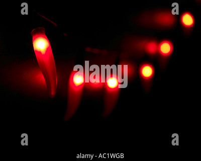 a string of red hot chilli lights against blackboard Stock Photo
