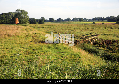 A landscape of grazing marshes with the derelict Womack Water Drainage Mill at Horse Fen, Ludham, Norfolk, England, United Kingdom. Stock Photo