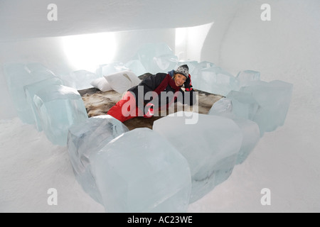 A tourist lying on a bed in a bedroom of the Jukkasjarvi ice hotel Stock Photo