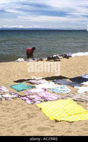Local woman drying clothes on the beach at Chikale Bay, Lake Malawi, Malawi Stock Photo