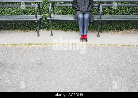 Young Woman Wearing Pink Socks Sitting On Park Bench Stock Photo