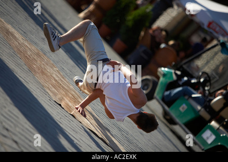 breakdancing young male street entertainer balancing on one hand in the rynek glowny main square in the old town krakow Stock Photo