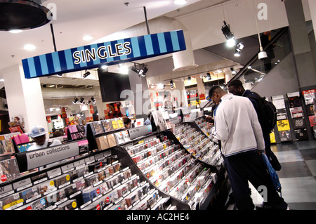 Young shoppers browsing through singles CDs at HMV store London England UK Stock Photo