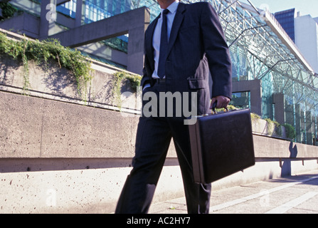 Businessman walks with briefcase Stock Photo