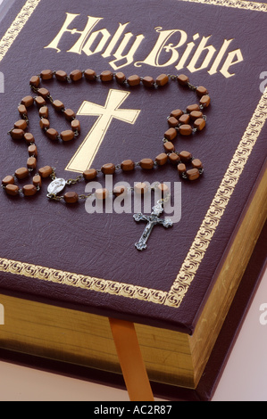 New Holy Bible with gold cross and Rosary prayer beads Stock Photo