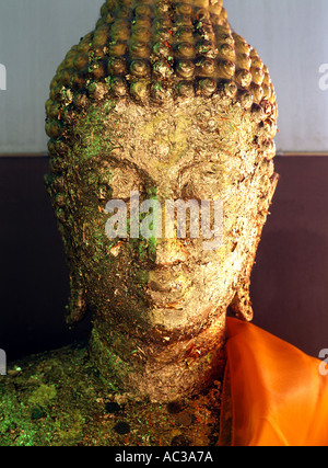 A Thai Buddha statue covered in gold leaf by visitors to the temple in Bangkok, Thailand Stock Photo
