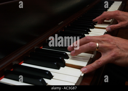 Close up of mans hands playing piano Stock Photo