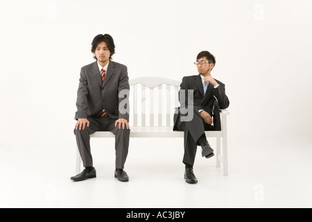 Two businessmen sitting on bench Stock Photo