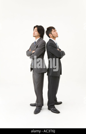 Two businessmen standing back to back Stock Photo