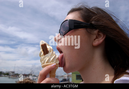 A brunette girl enjoys an ice cream cone in Littlehampton UK Stock Photo