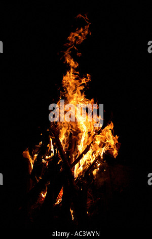 Vibrant campfire flames illuminate dark wilderness night with bright ...
