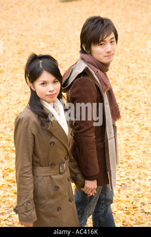 Young couple walking on fallen leaves Stock Photo