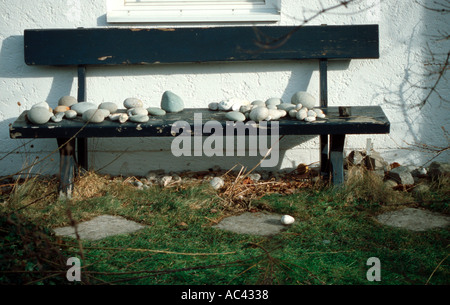 white stones lying on a green bench in the summer sun near Ammersee Bavaria Germany Stock Photo