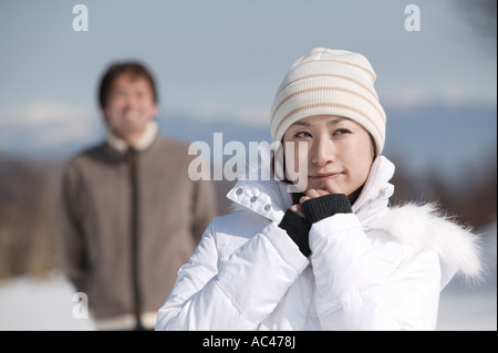 Young woman smiling boyfriend in background Stock Photo