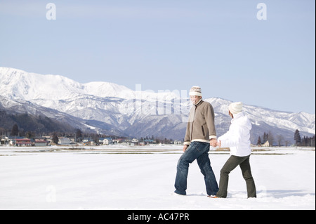 Young couple walking in snow Stock Photo