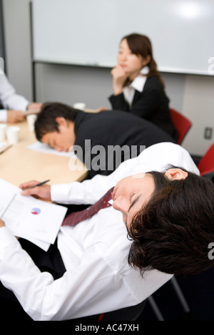 Young businessmen sleeping during meeting Stock Photo