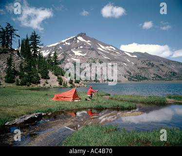 Camper at Green Lakes admiring the view of South Sister Mountain Oregon s third highest peak at 10358 feet elevation Stock Photo