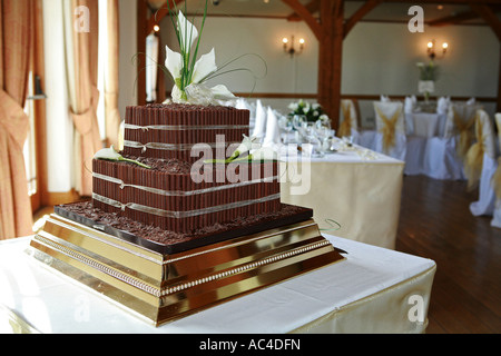 A non traditional brown chocolate covered wedding cake awaits a wedding reception on a wedding day greeting card image UK Stock Photo