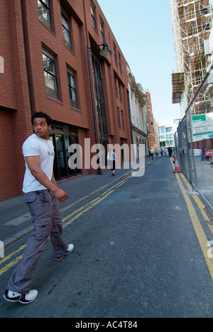 Young man looking over shoulder about to run away Manchester City centre GB UK EU Europe Stock Photo