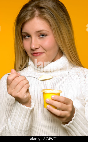 Caucasian teenage girl (16–18) smiling while enjoying banana pudding in the USA. Stock Photo