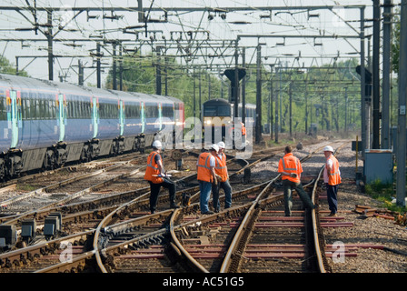 Liverpool Street main railway line to East Anglia high visibility track maintenance men work beside trains at Shenfield Station Essex England UK Stock Photo